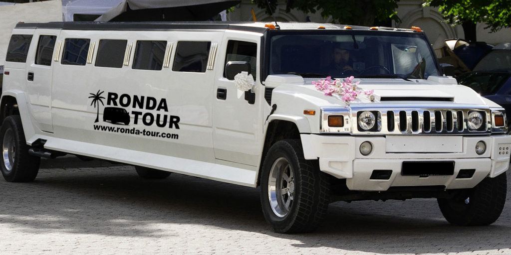 Humer Limousine blanc décoré pour un mariage. Filigrane avec le logo de Ronda Tour et son adresse web www.ronda-tour.com sur la photo.