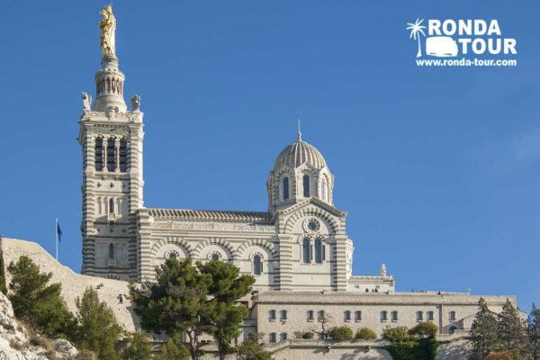 Basilique Notre Dame de la Garde à Marseille vue de face avec un super ciel azur. Filigrane avec le logo de Ronda Tour et son adresse web www.ronda-tour.com sur la photo.