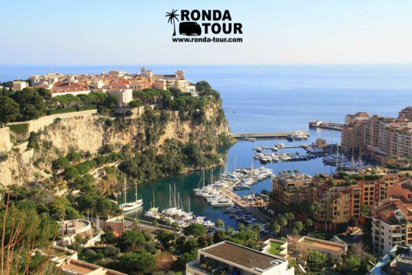 Vue sur le Rocher et le quartier Fontvieille de Monaco. Il y a un filigrame contenant le logo Ronda Tour et son a dresse web www.ronda-tour.com