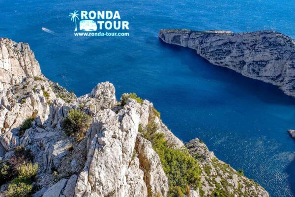 Calanques de Marseille . Joli contraste entre la roche blanche et le bleu de la mer Méditerranée. Filigrane avec le logo de Ronda Tour et son adresse web www.ronda-tour.com sur la photo.