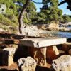 Jolie table et chaises de pics nique en pierrre dans un paysage naturel sur l'île Sainte Marguerite. Filigrane avec le logo de Ronda Tour et son adresse web www.ronda-tour.com sur la photo.